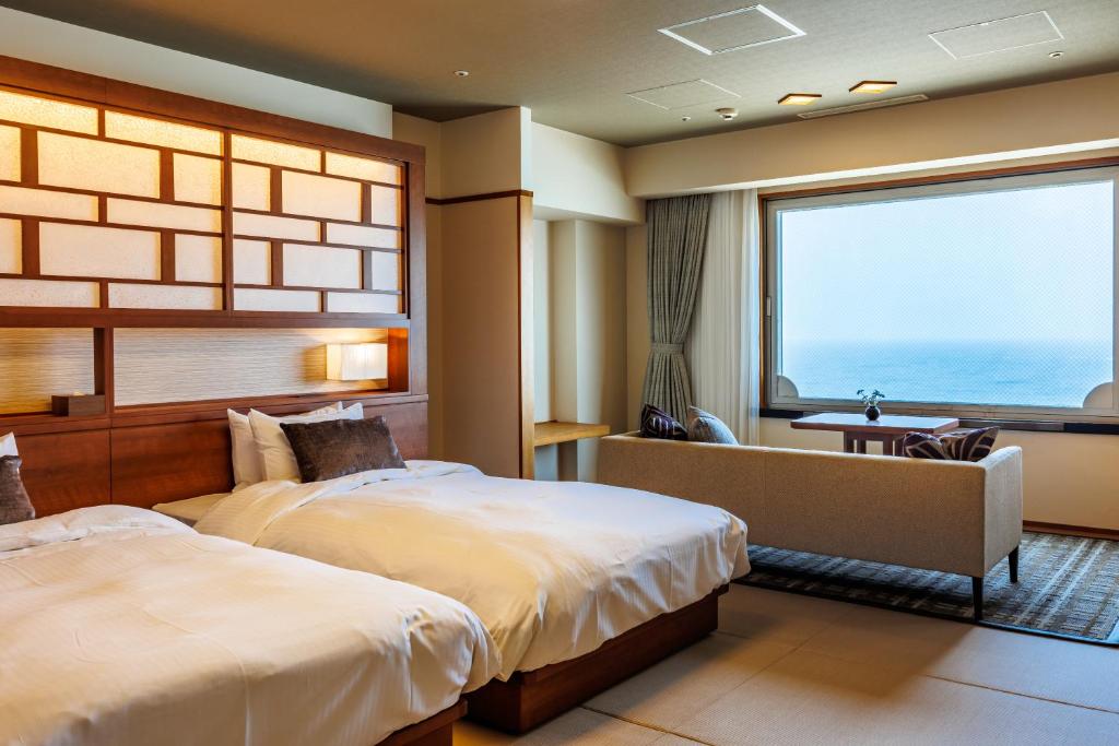 une chambre d'hôtel avec deux lits et une grande fenêtre dans l'établissement Hotel Oosado, à Sado