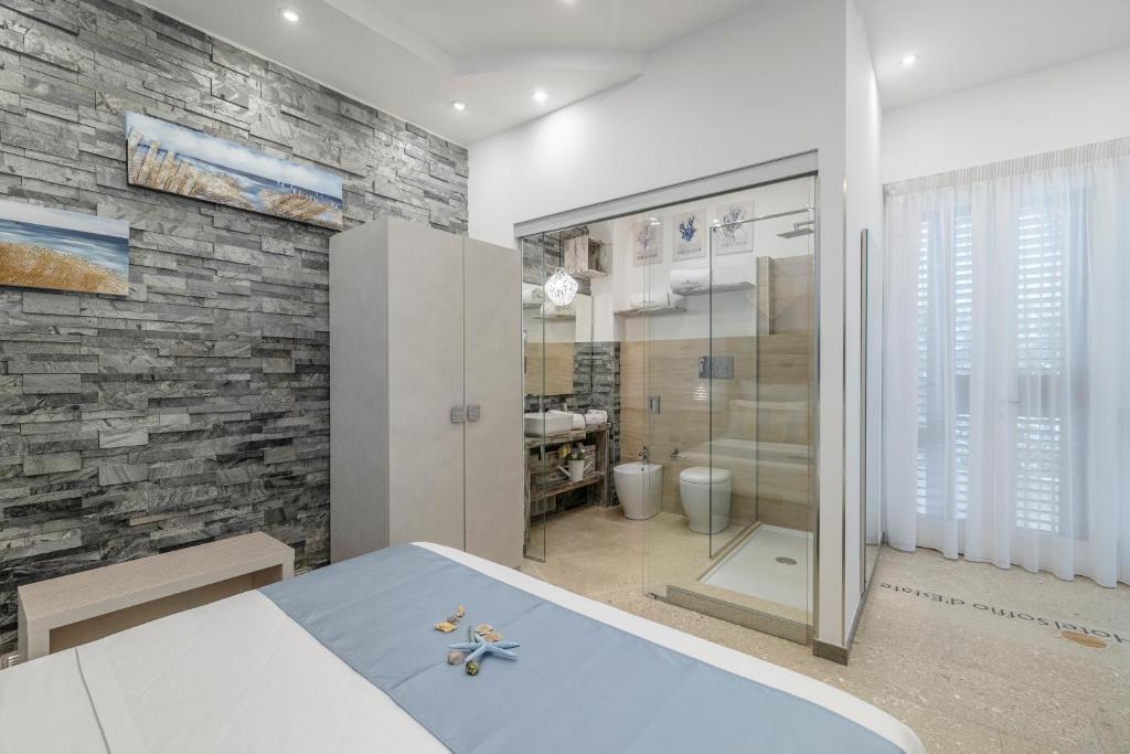 une chambre avec un lit et une salle de bain avec douche dans l'établissement Hotel Soffio D'Estate, à San Vito Lo Capo