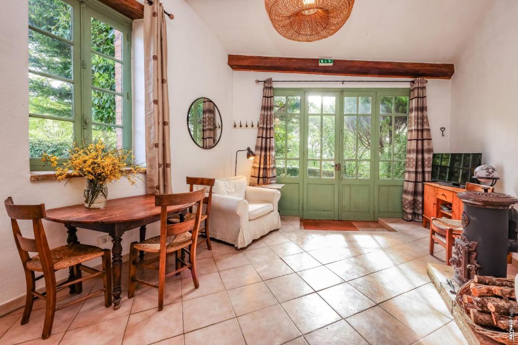 un salon avec une table et une chaise dans l'établissement Les Hauts de Jeanvert - Gite de Charme - Piscine - Gaillac, à Gaillac 25 autres photos