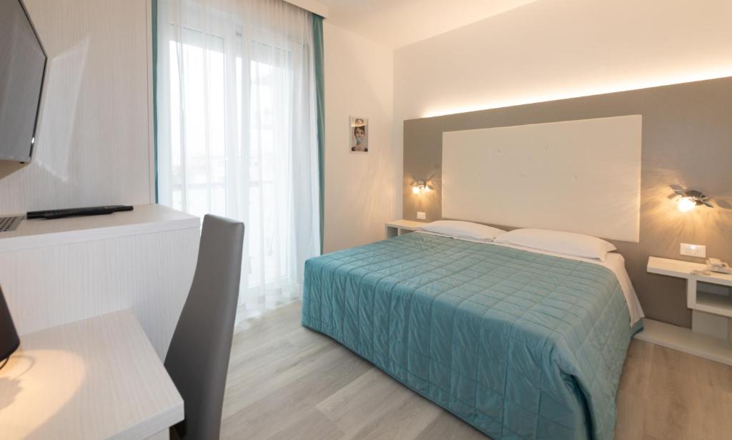 une chambre avec un lit et une grande fenêtre dans l'établissement Hotel & Aparthotel Carinthia S, à Lido di Jesolo