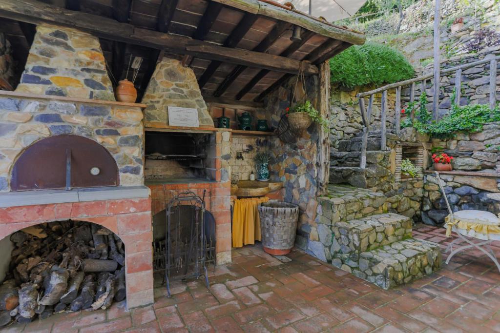 une cuisine extérieure avec une cheminée en pierre et un escalier dans l'établissement Villa sii felice, à Buti