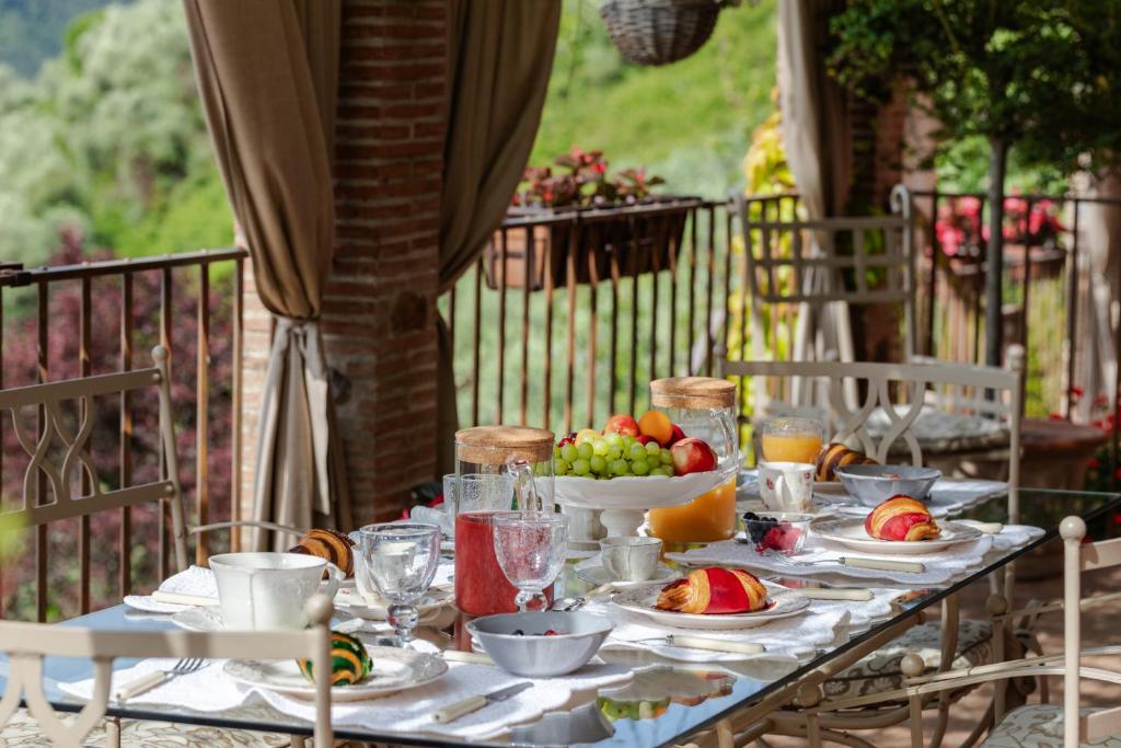 - une table avec des assiettes de nourriture et des fruits dans l'établissement Villa sii felice, à Buti