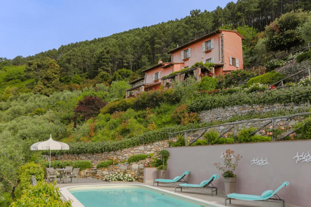 une maison sur le flanc d'une colline avec une piscine dans l'établissement Villa sii felice, à Buti