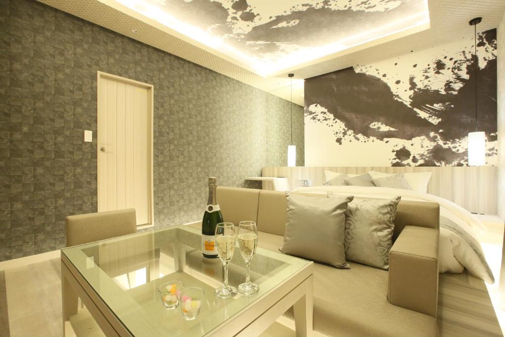 un salon avec une bouteille de vin et des verres sur une table dans l'établissement HOTEL Miz, à Rifu