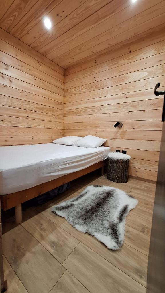 une chambre avec un lit dans une pièce en bois dans l'établissement Appartement chaleureux en cœur de station, à Laruns