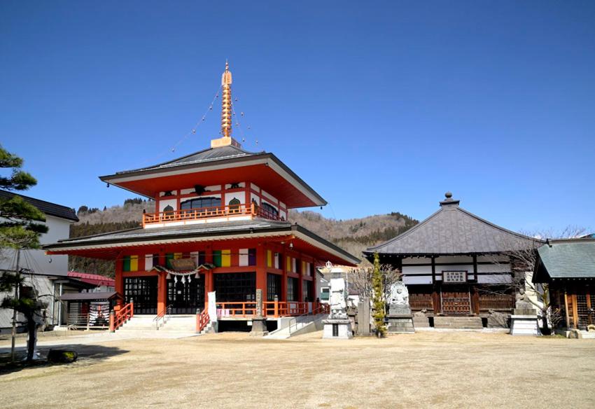 un grand bâtiment avec une tour au sommet dans l'établissement Historical Ryokan SENYUKAN, à Ōwani