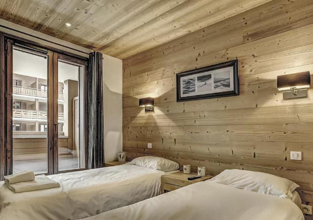 - 2 lits dans une chambre avec un mur en bois dans l'établissement Charming Apartment Chamonix Valley, à Vallorcine