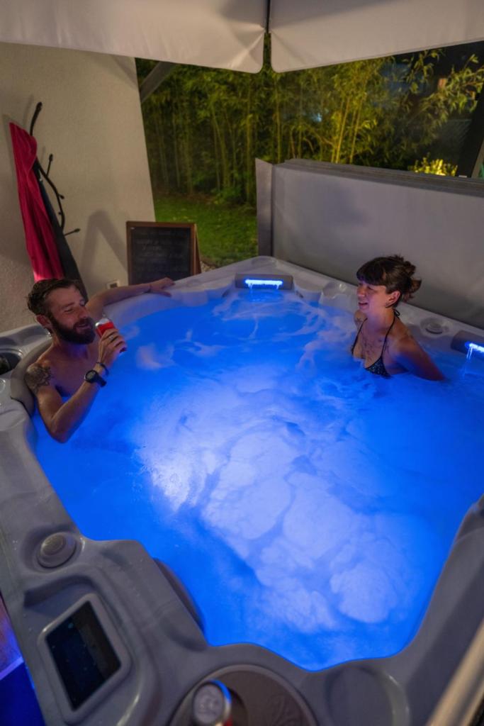 deux personnes dans un jacuzzi avec de l'eau bleue dans l'établissement Caldonazzo Dog Sport & Wellness, à Caldonazzo