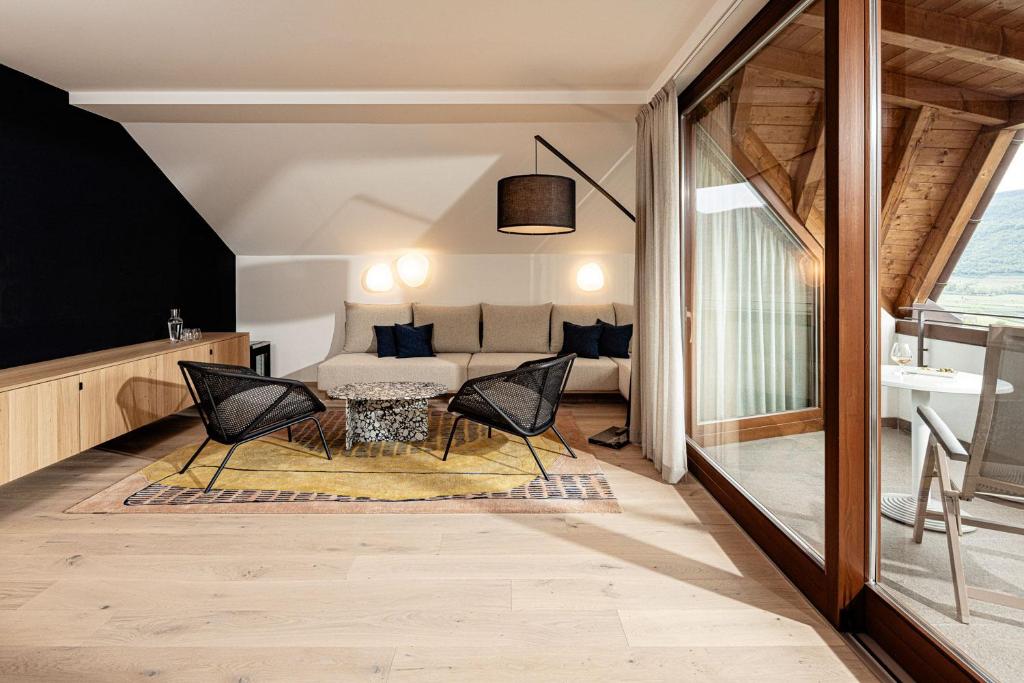 une chambre avec un lit, une table et des chaises dans l'établissement Hotel Haus am Hang, à Caldaro