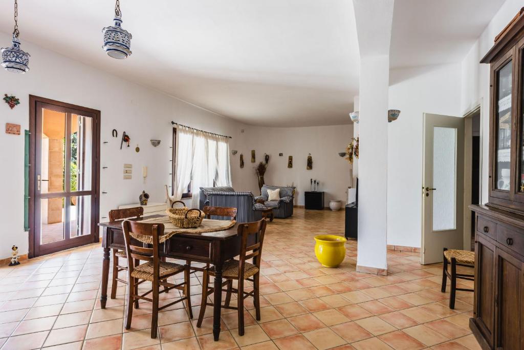 un grand salon avec une table et des chaises dans l'établissement Villa Arenella con piscina, à Syracuse