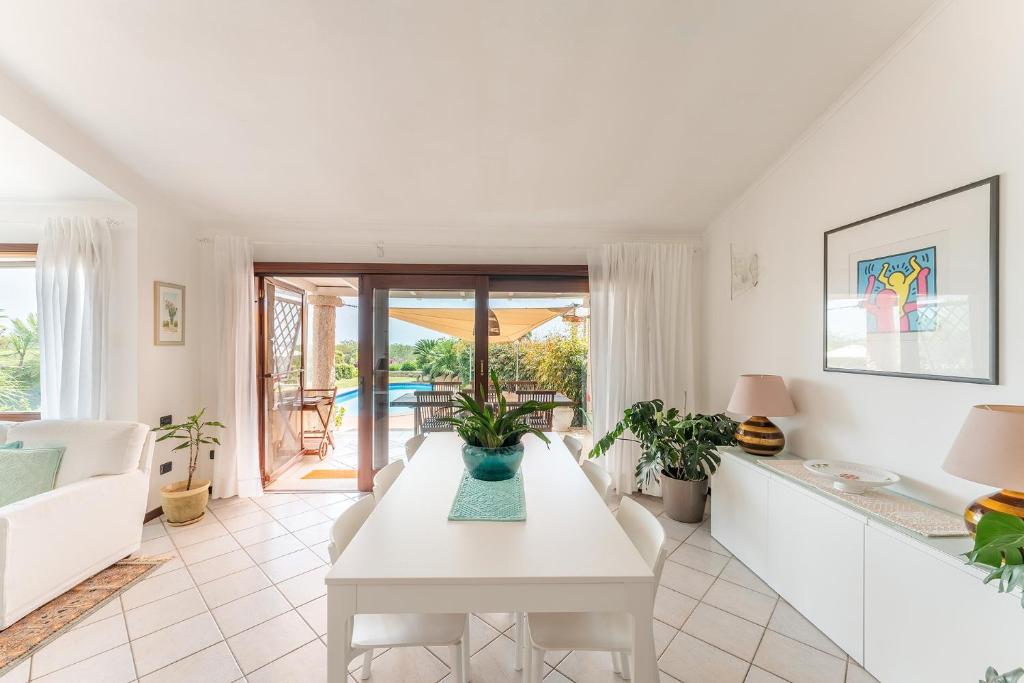 un salon avec une table blanche et un canapé dans l'établissement Oasi Colombina, Private Pool, à Is Molas