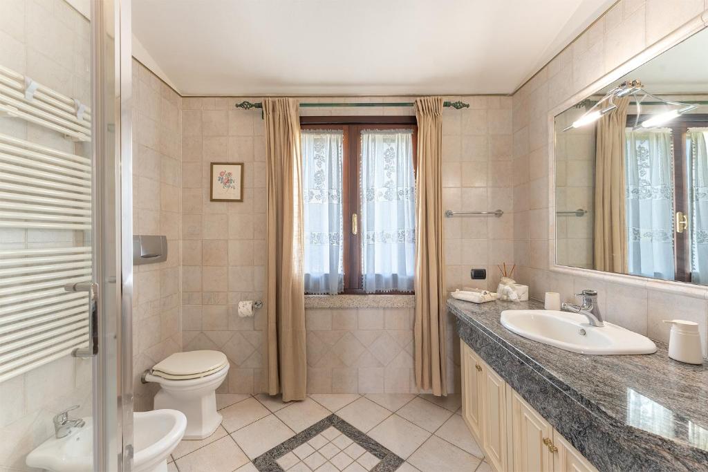 une salle de bain avec un lavabo, des toilettes et un miroir dans l'établissement Oasi Colombina, Private Pool, à Is Molas