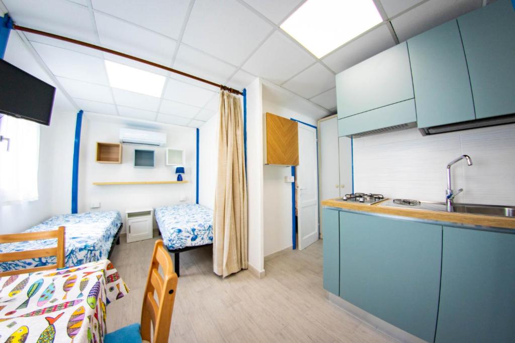 une pièce avec une cuisine, un lit et un lavabo dans l'établissement Residence Eden, à Comacchio