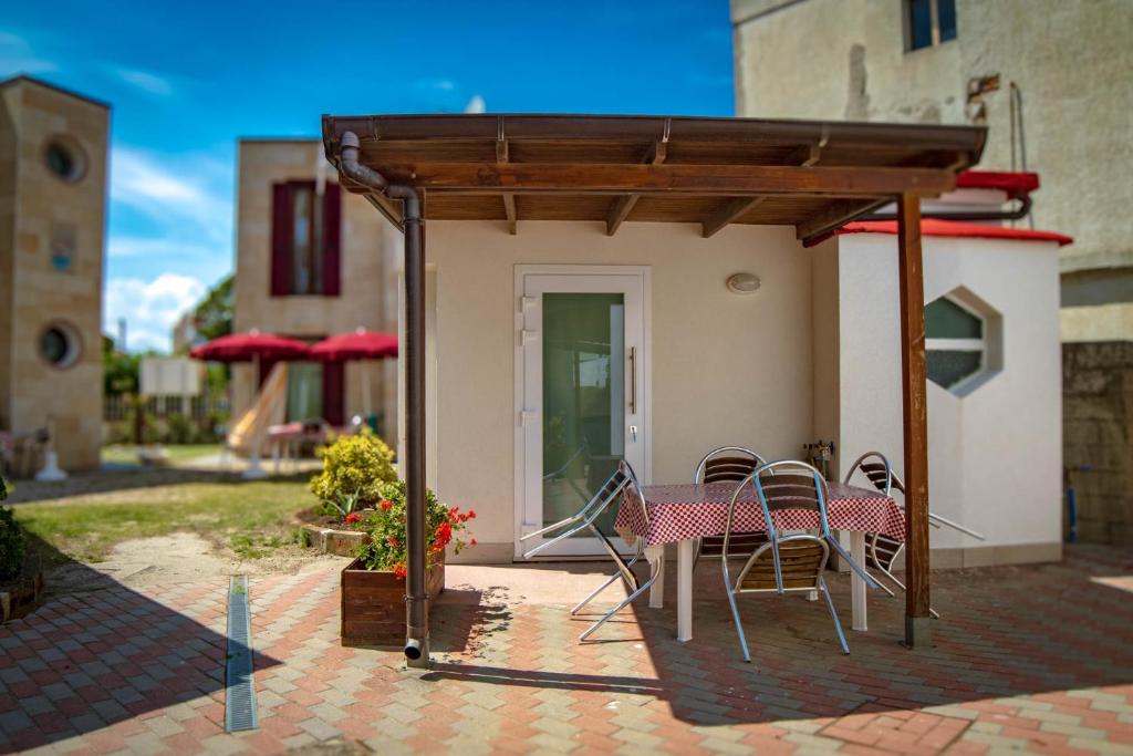 un patio avec une table et des chaises sous un pavillon dans l'établissement Residence Eden, à Comacchio