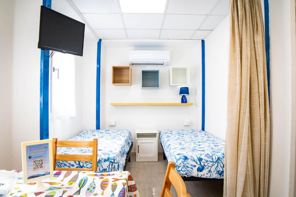 une petite chambre avec deux lits et une télévision dans l'établissement Residence Eden, à Comacchio