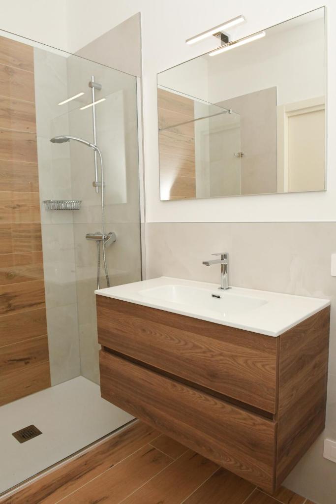une salle de bain avec un lavabo et une douche avec un miroir dans l'établissement NEW Villa Tosca, à Bardolino 44 autres photos