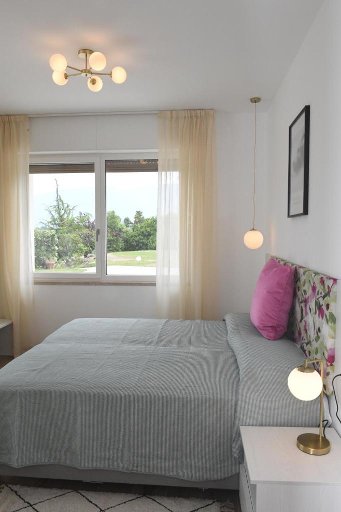 une chambre avec un grand lit et une fenêtre dans l'établissement NEW Villa Tosca, à Bardolino