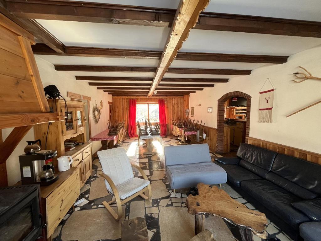 - un salon avec un canapé et des fauteuils en cuir noir dans l'établissement LE CHAMOIS, à La Poutuire
