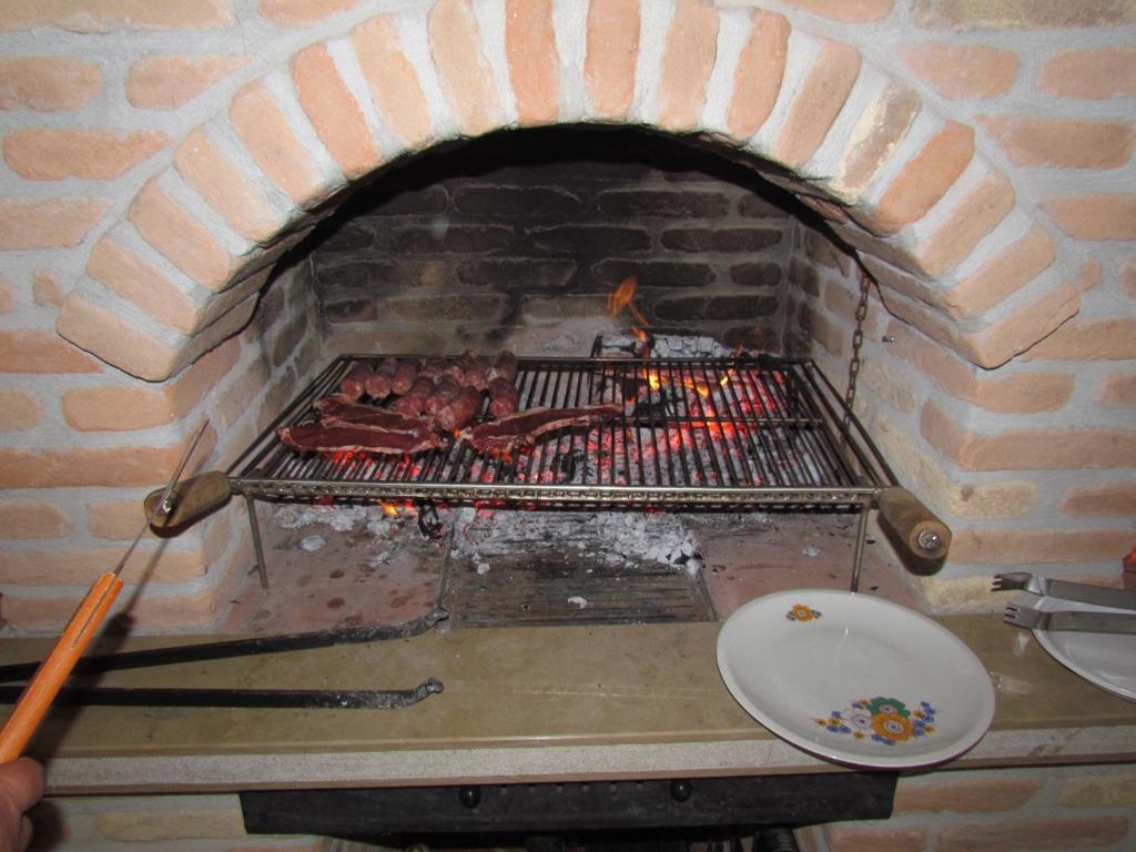 - un four en briques avec un grill et de la viande dans l'établissement Tenuta Armida Relax & Pool, à Liberi