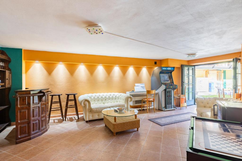 un salon avec des murs orange et un canapé et une table dans l'établissement "Il Vicolo" Sunny Lake Garda Villa, à Toscolano Maderno