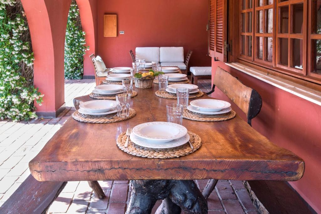 une table en bois avec des assiettes et des verres dans l'établissement Villa MariSoul - Villa in San Felice Circeo, à Borgo Montenero
