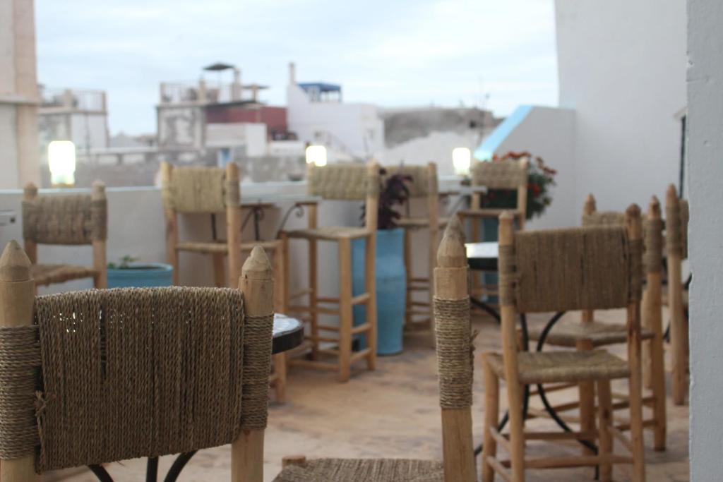 un groupe de chaises et de tables dans une pièce dans l'établissement Riad Inna & Watersports Center, à Essaouira 36 autres photos
