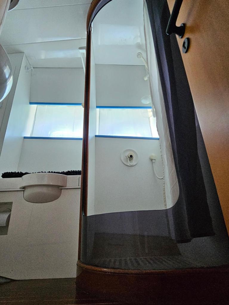 une petite salle de bain avec un lavabo et des toilettes dans l'établissement Nuit insolite bateau à quai - Port Saint Louis du Rhône, à Port-Saint-Louis-du-Rhône