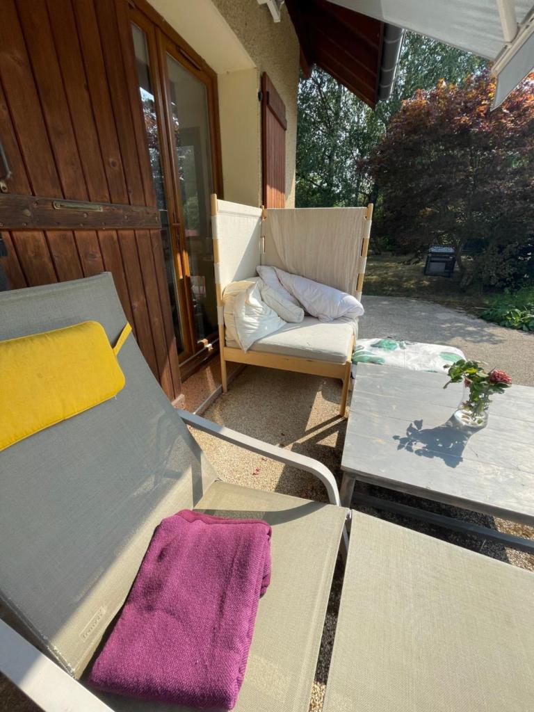 un patio avec une chaise et un canapé sur un porche dans l'établissement Salève Glamping, à Archamps