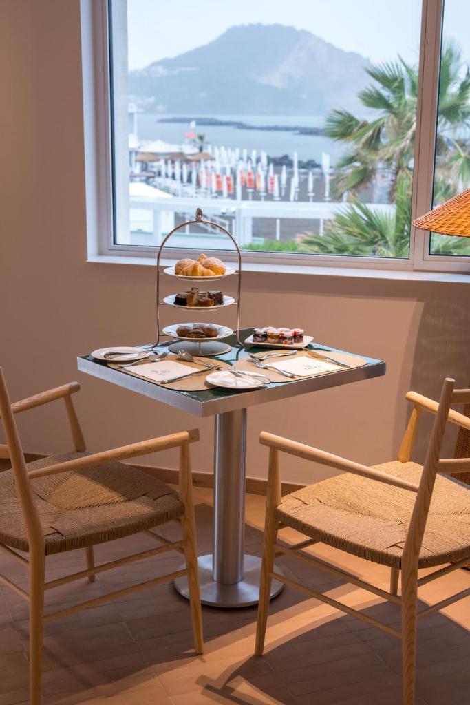 - une table avec un plateau de pâtisseries à côté d'une fenêtre dans l'établissement CALEA Boutique Hotel, à Bacoli 51 autres photos