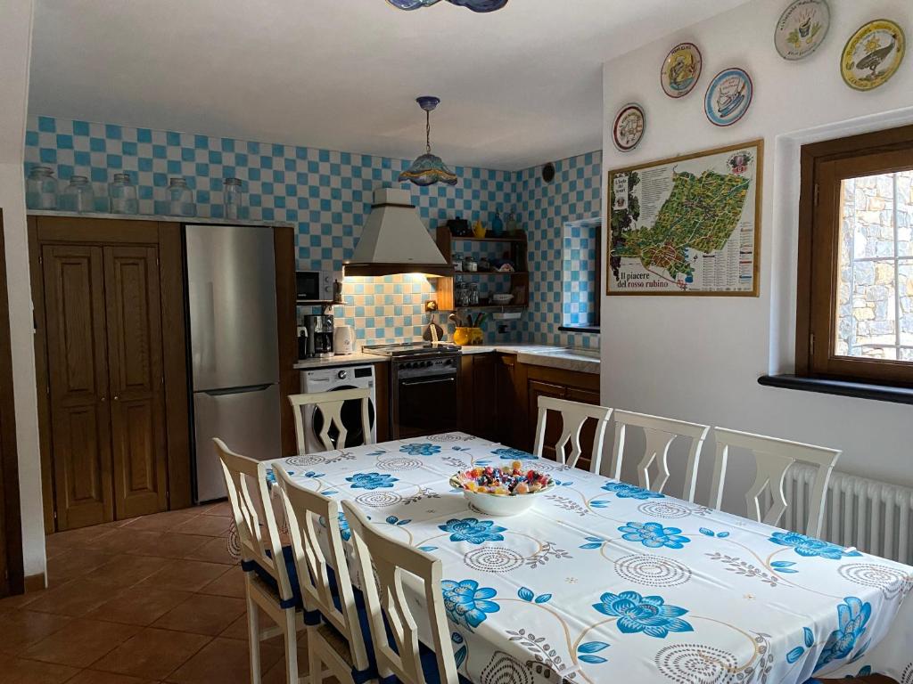 Il comprend une cuisine équipée d'une table et d'un réfrigérateur. dans l'établissement Villa Mulino, à Borganzo