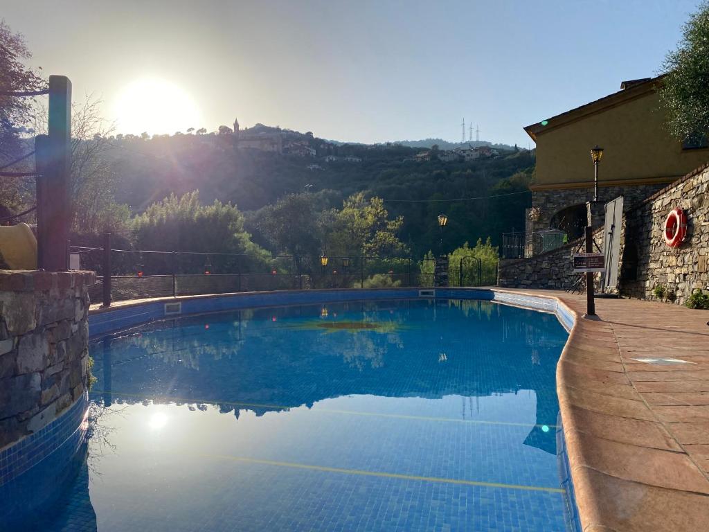 - une grande piscine au soleil en arrière-plan dans l'établissement Villa Mulino, à Borganzo