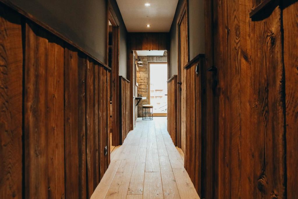 un couloir vide avec des murs en bois et du parquet dans l'établissement Duplex Encombres by Lodji, à Saint-Martin-de-Belleville 31 autres photos
