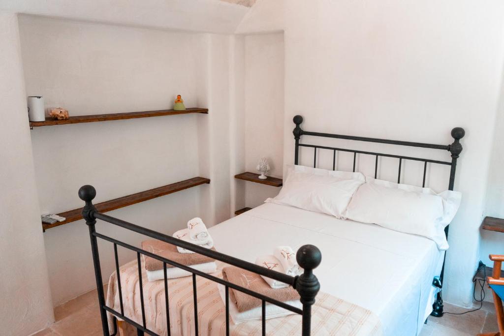 - une chambre avec un lit noir et des oreillers blancs dans l'établissement Maison Trullo, à Ceglie Messapica 42 autres photos