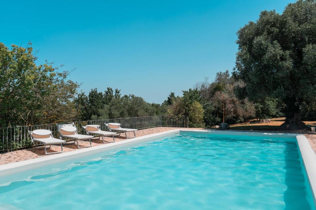 une piscine avec des chaises longues et une piscine dans l'établissement Maison Trullo, à Ceglie Messapica