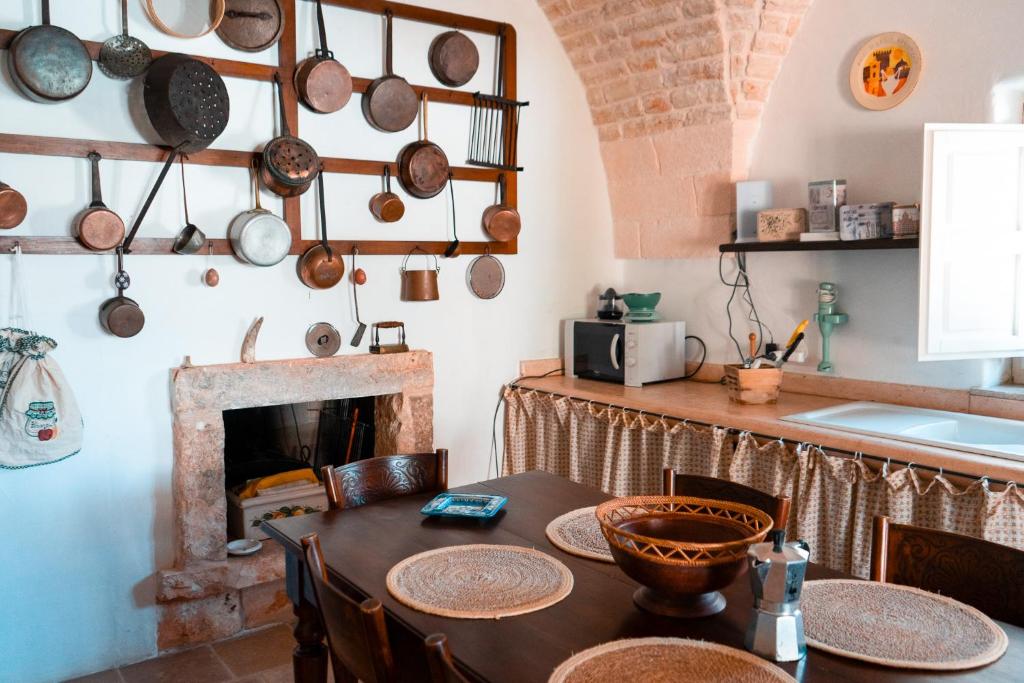 - une cuisine avec une table et une cheminée dans l'établissement Maison Trullo, à Ceglie Messapica