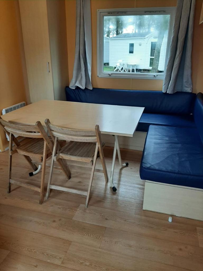 - un salon avec une table et des chaises dans l'établissement Mobil-home Puy du Fou, à La Boissière-de-Montaigu