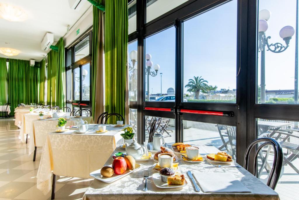 une rangée de tables avec de la nourriture dessus dans un restaurant dans l'établissement Hotel Lungomare, à Cervia