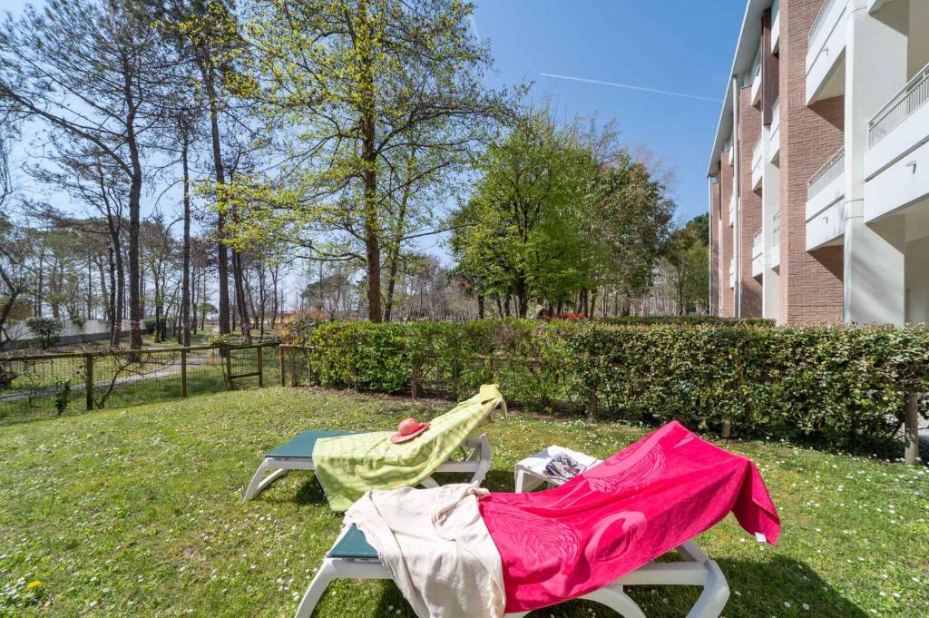 une couverture rose posée sur une chaise dans une cour dans l'établissement Residenza Al Parco, à Bibione