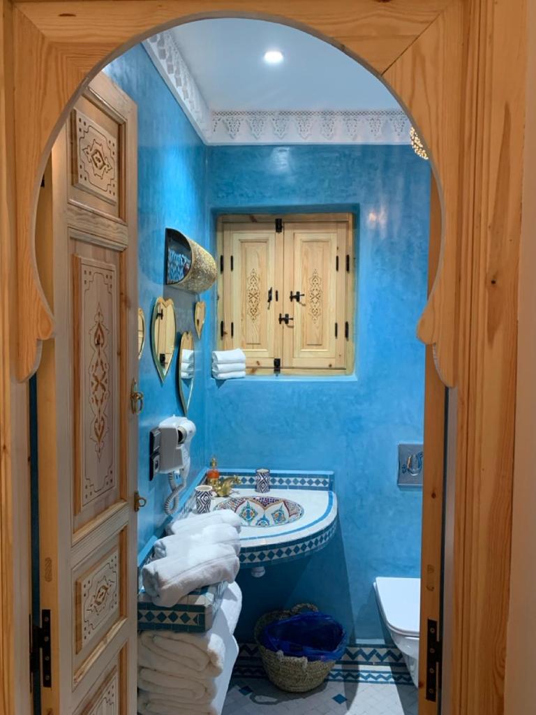 une salle de bain bleue avec un lavabo et un miroir dans l'établissement Riad SunSet Marrakech, à Marrakech