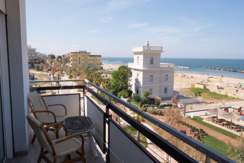 un balcon avec deux chaises et un phare sur une plage dans l'établissement Hotel Re Leone, à Rimini