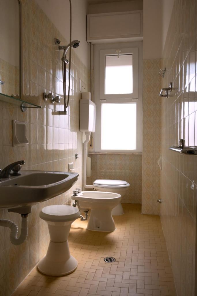 La salle de bains est pourvue de 2 toilettes, d'un lavabo et d'une fenêtre. dans l'établissement Hotel Re Leone, à Rimini 57 autres photos
