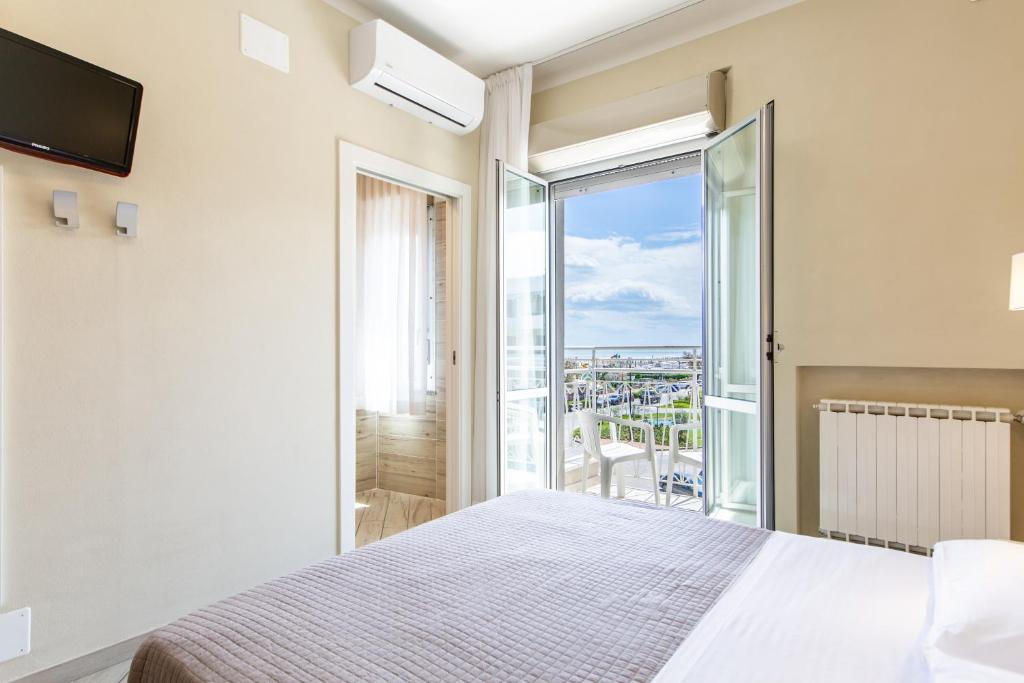 une chambre avec un lit et un balcon dans l'établissement Hotel Lungomare, à Cervia
