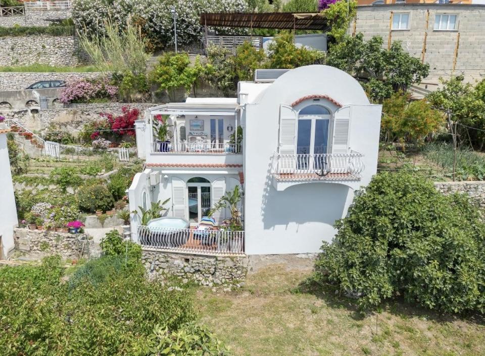 - une vue aérienne sur une maison blanche avec un jardin dans l'établissement Villa Navarra, à Praiano