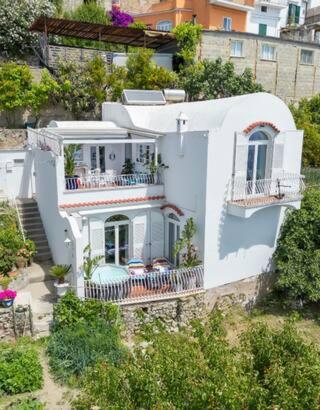 Elle offre une vue aérienne sur une maison blanche dotée d'un balcon. dans l'établissement Villa Navarra, à Praiano