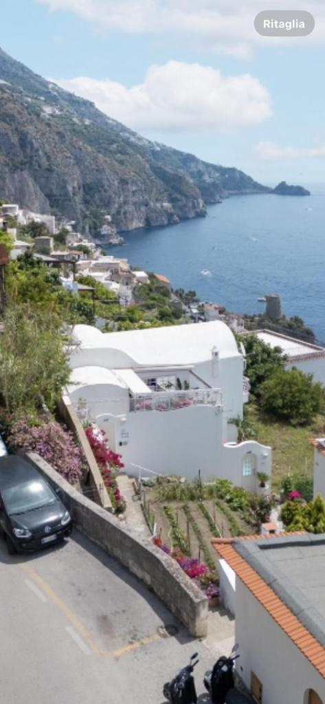 une voiture garée dans un parking à côté d'un bâtiment blanc dans l'établissement Villa Navarra, à Praiano