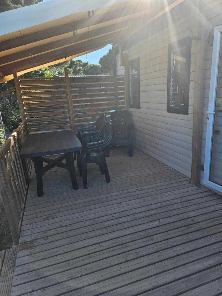 une terrasse avec une table de pique-nique et un banc dans l'établissement Mobilhome 6 personnes camping la falaise, à Narbonne