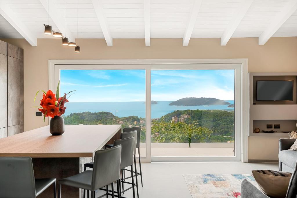 une salle à manger avec une table et une grande fenêtre dans l'établissement Colori di Mare Luxury Holiday, à Lerici