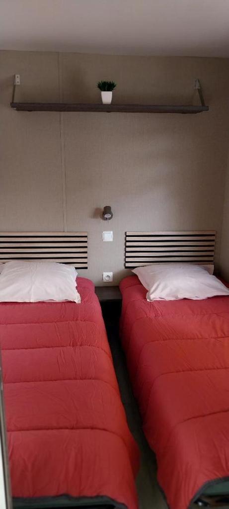 deux lits côte à côte dans une pièce dans l'établissement Mobilhome cosy Aulywan, à La Boissière-de-Montaigu 30 autres photos