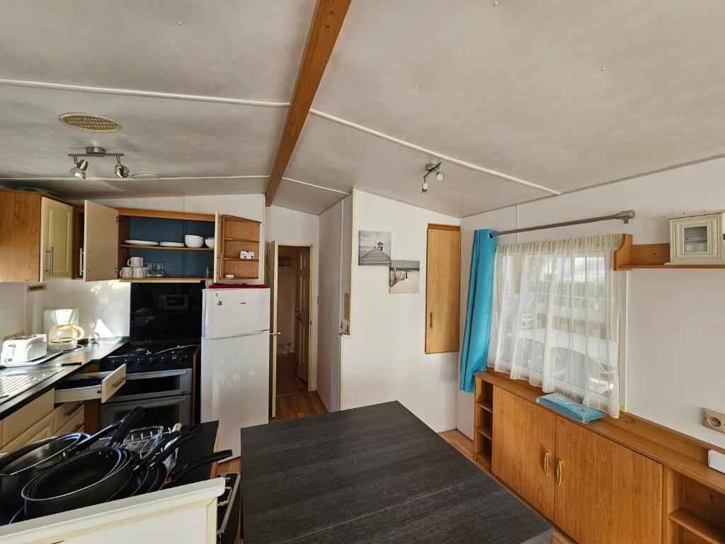 une cuisine avec une table noire dans l'établissement Mobil home 6 personnes, à Saint-Jean-de-Monts