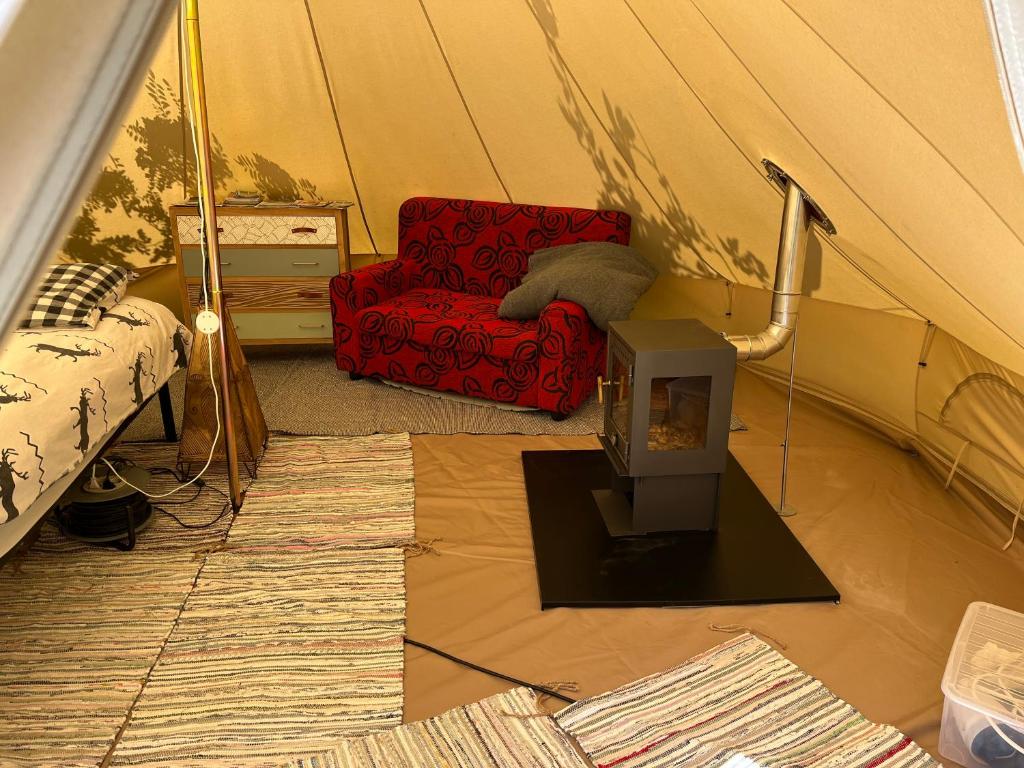 une tente avec une chaise et une télévision dans une pièce dans l'établissement Tente inuite, à Tende